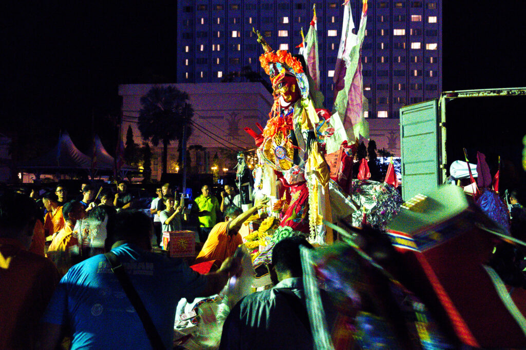 祭礼の壇から運ばれた「King」の像の周囲で祈りを捧げる