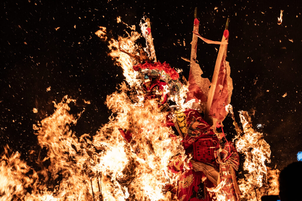 激しく燃える「King」の像と、人ともに舞い上がる紙銭